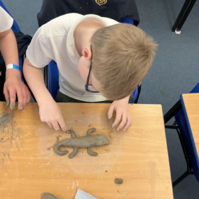 Children making clay lizards
